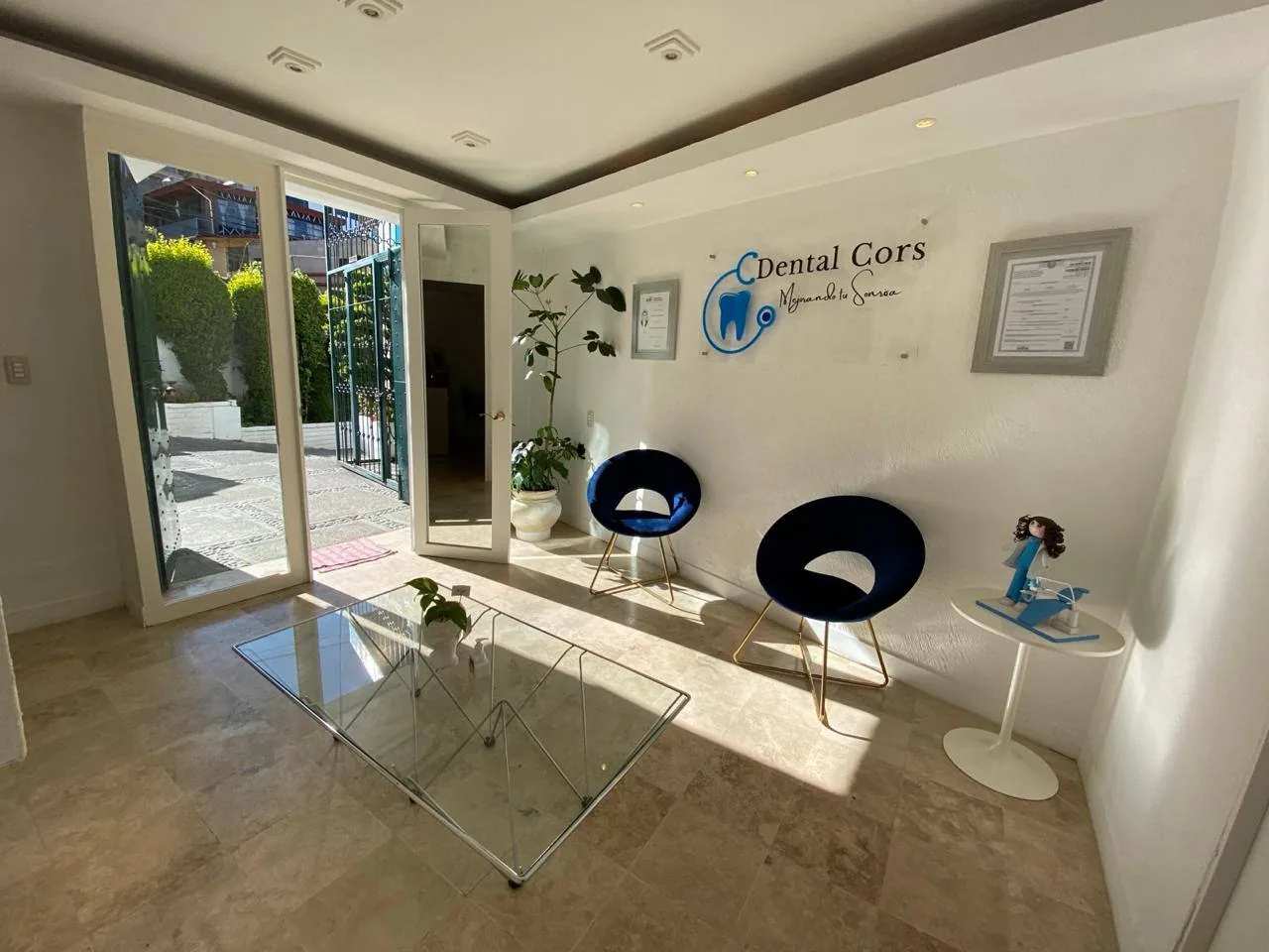 Sala de recepción de Dental Cors en Santa Rosa Xochiac, con el logotipo de la clínica en la pared